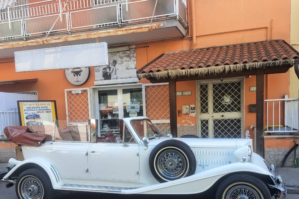 La vetrina con l'insegna L'Auto Sposa Vergara al civico 141, con un'auto scoperta bianca dagli interni scuri parcheggiata davanti
